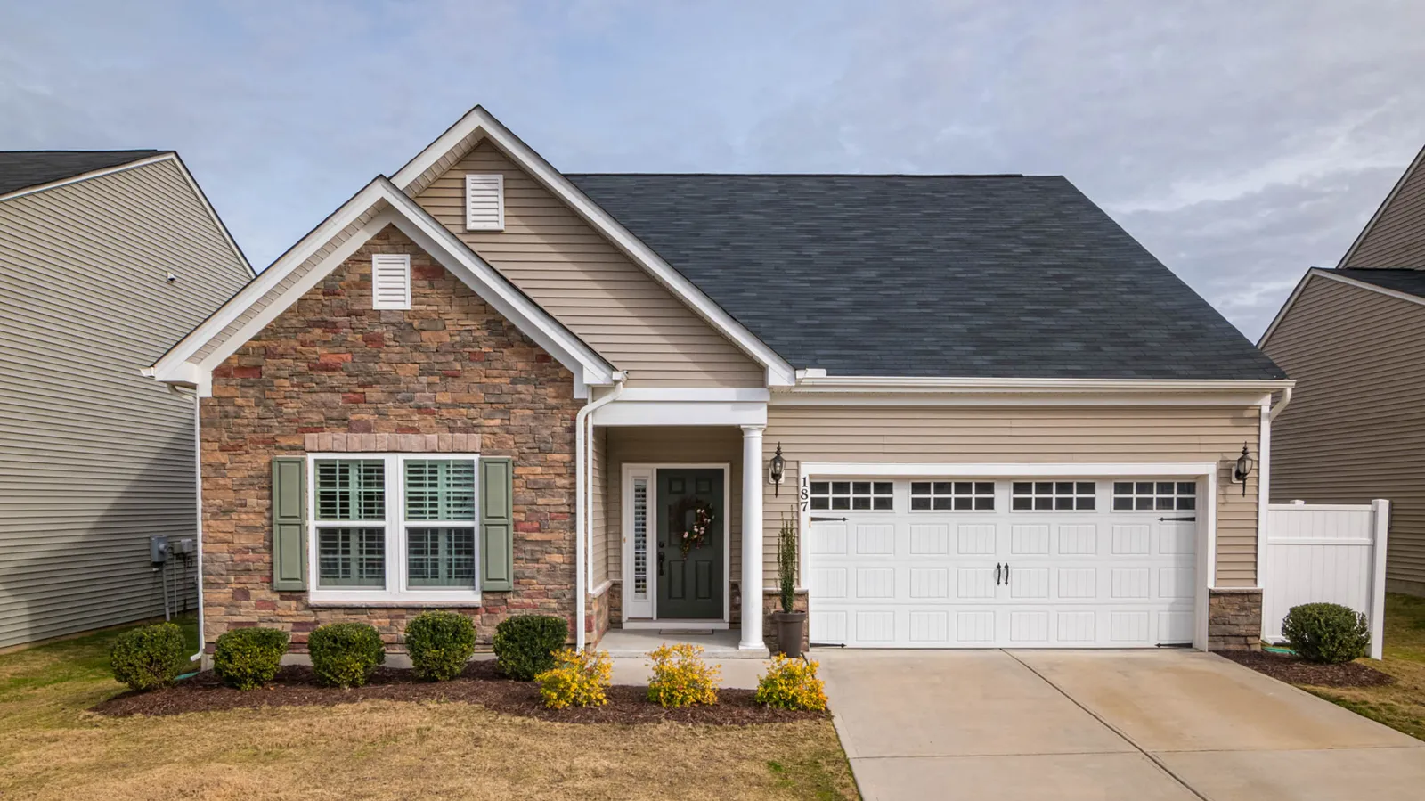 Ranch home with stone accents and a dark gray asphalt shingle roof