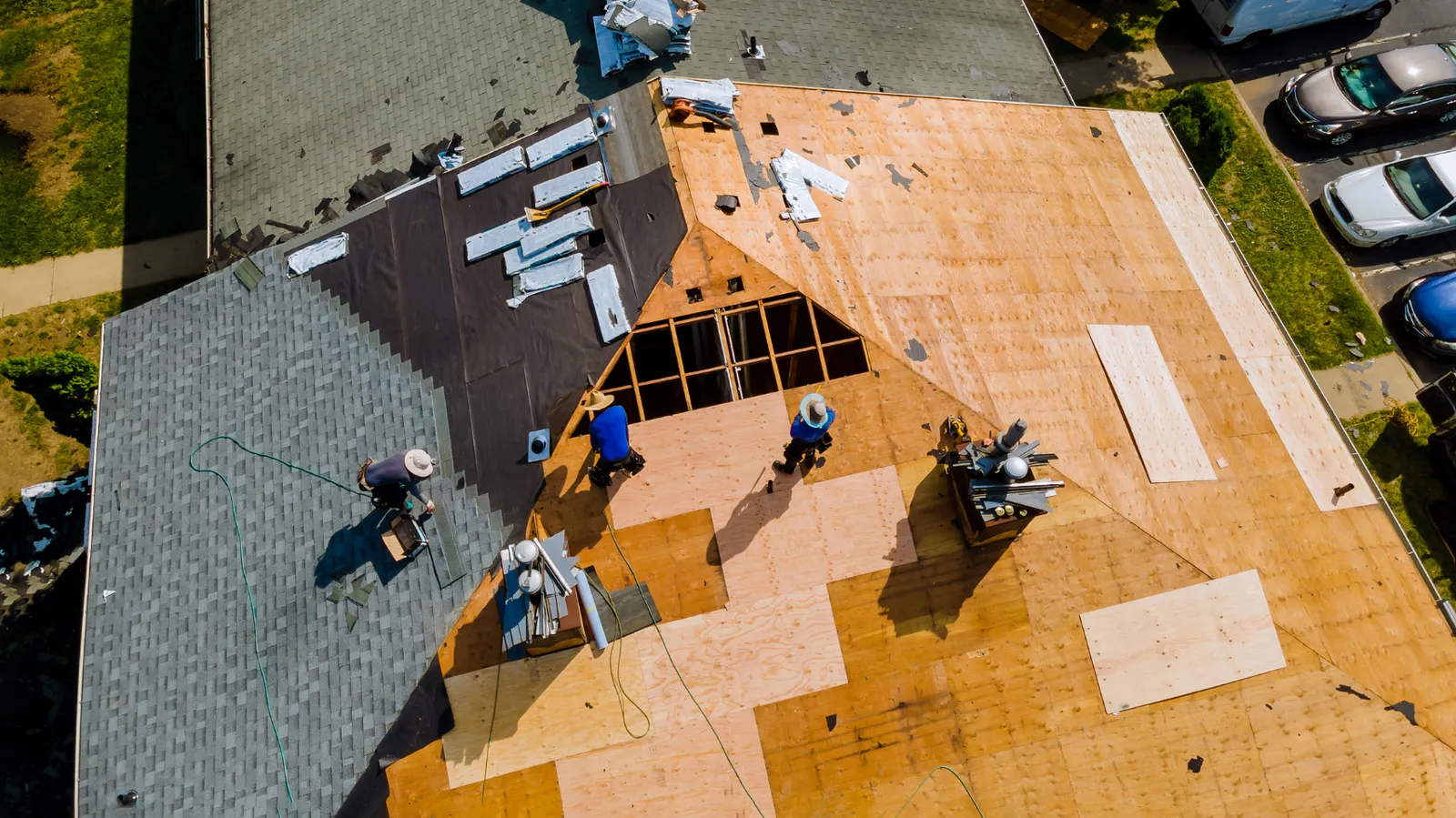 Large roof viewed from overhead as roofers replace shingles